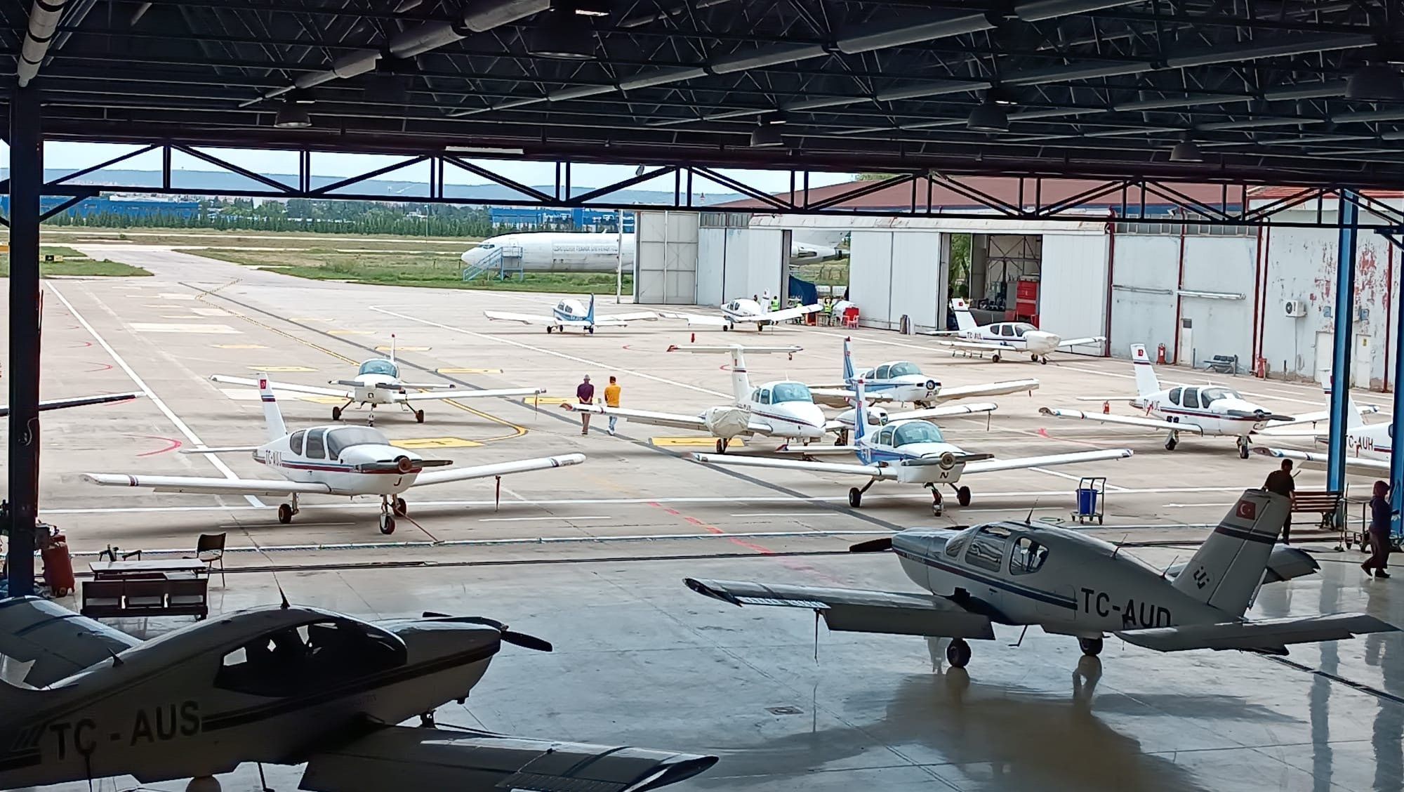 Training aircraft on the apron, seen from inside the hangar