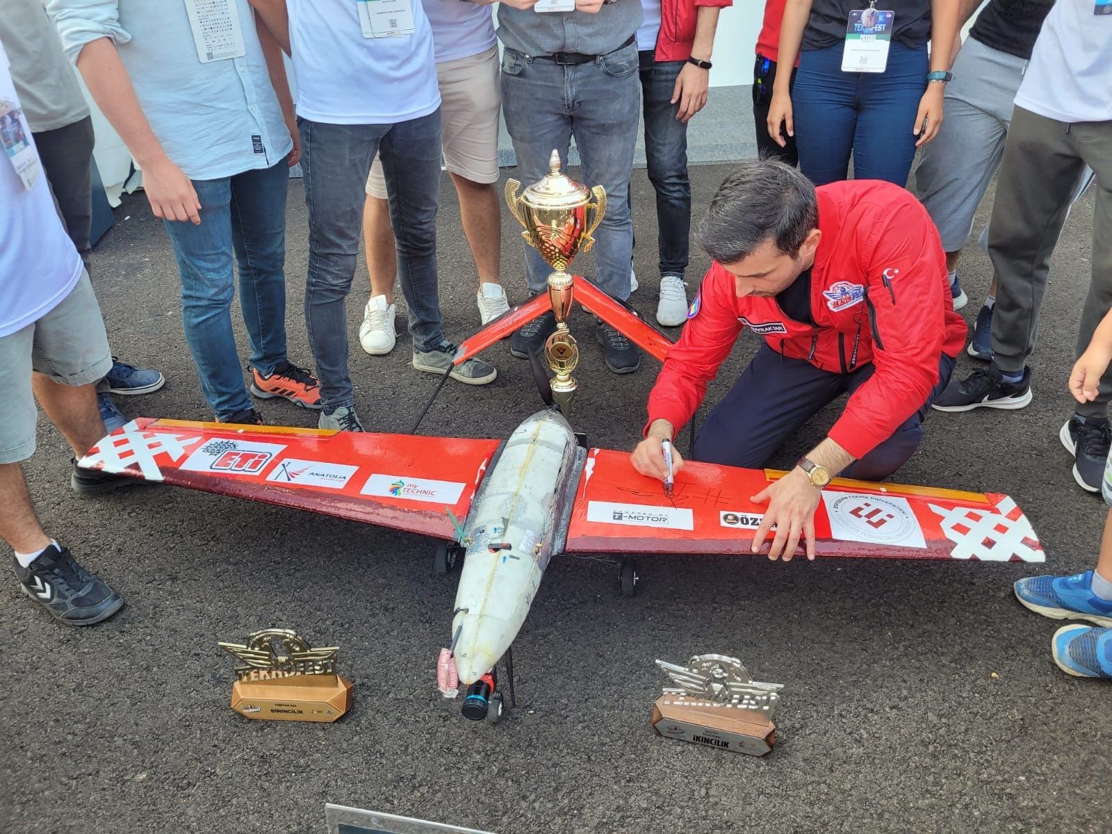 2022, TEKNOFEST: The team’s aircraft being signed, next to the trophy.